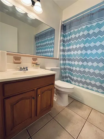 a bathroom with a sink a toilet and shower curtain