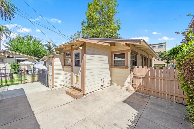 a view of a white house with iron fence