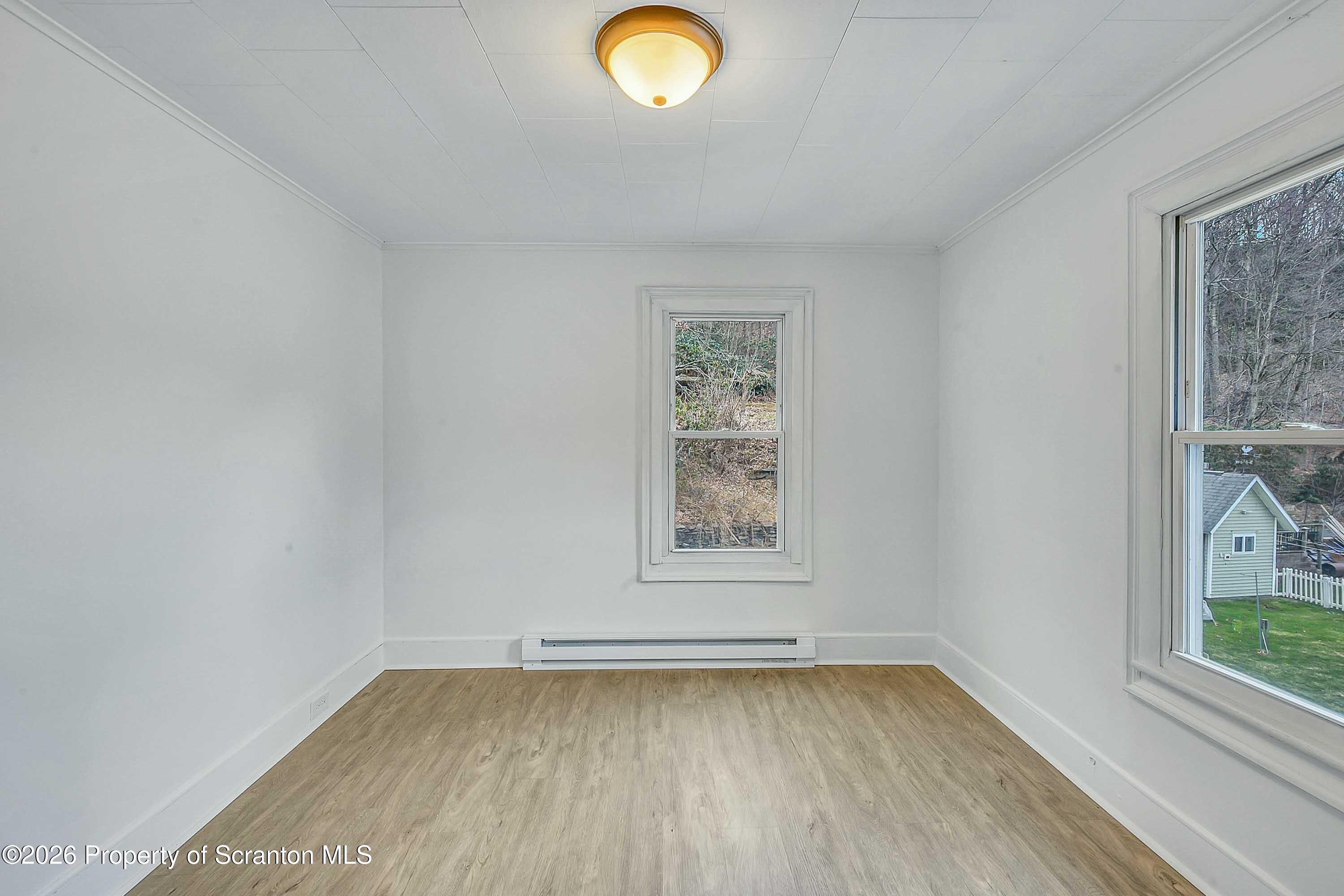 602 Main Street Archbald, PA 18403 - Photo 19 of 26 an empty room with wooden floor and windows