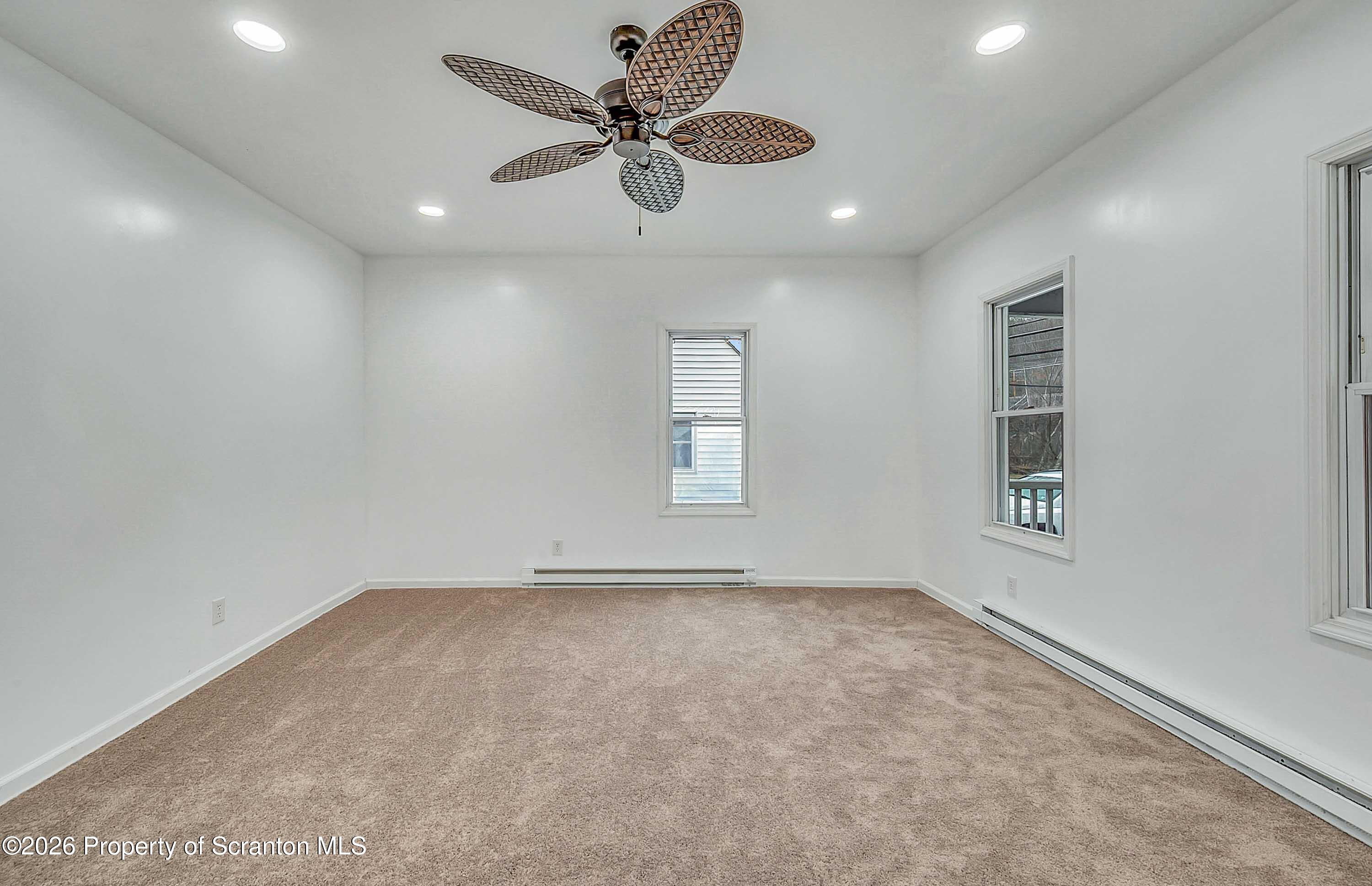 602 Main Street Archbald, PA 18403 - Photo 4 of 26 an empty room with a ceiling fan and window