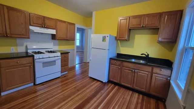 a kitchen with granite countertop wooden floors and stainless steel appliances
