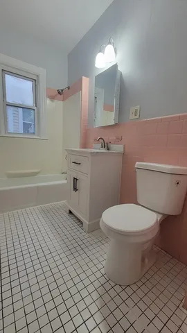a bathroom with a toilet a sink and mirror
