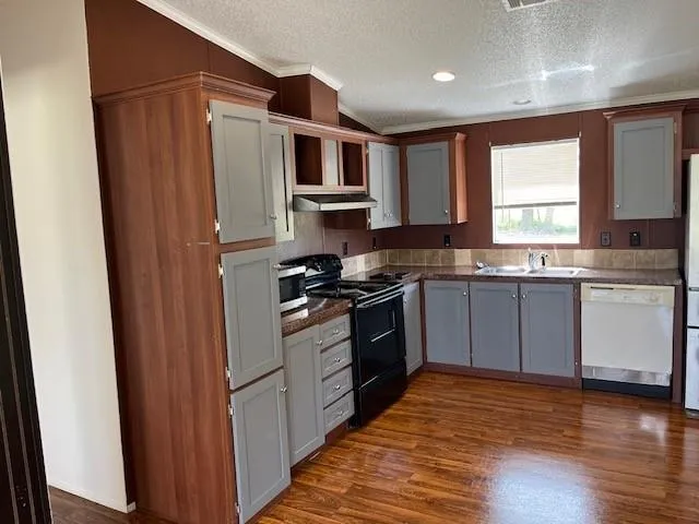 a kitchen with stainless steel appliances granite countertop a stove a sink and a refrigerator