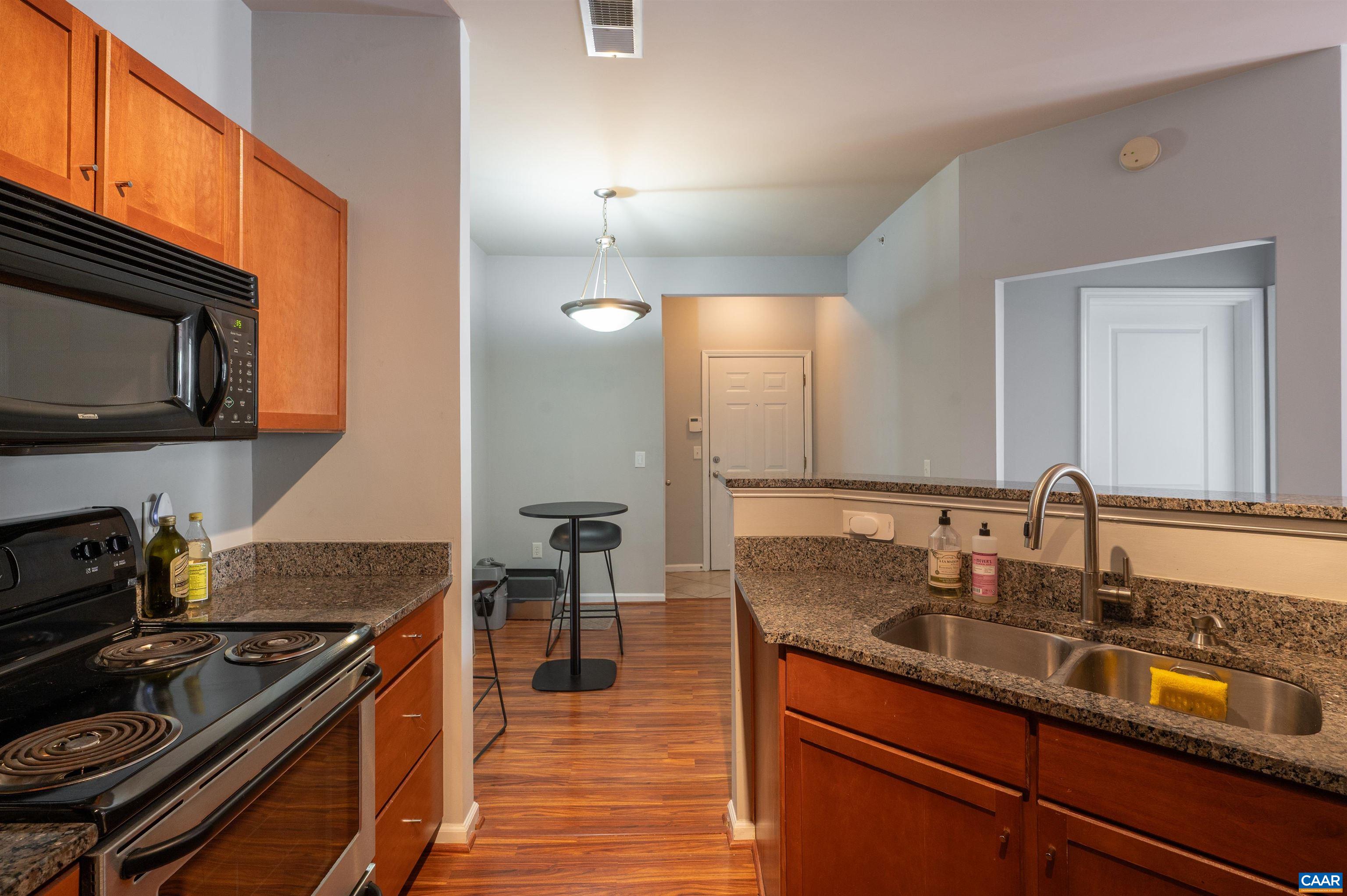 735 Walker Square, Unit 2A Charlottesville, VA 22903 - Photo 5 of 30 a kitchen with granite countertop stainless steel appliances and wooden cabinets