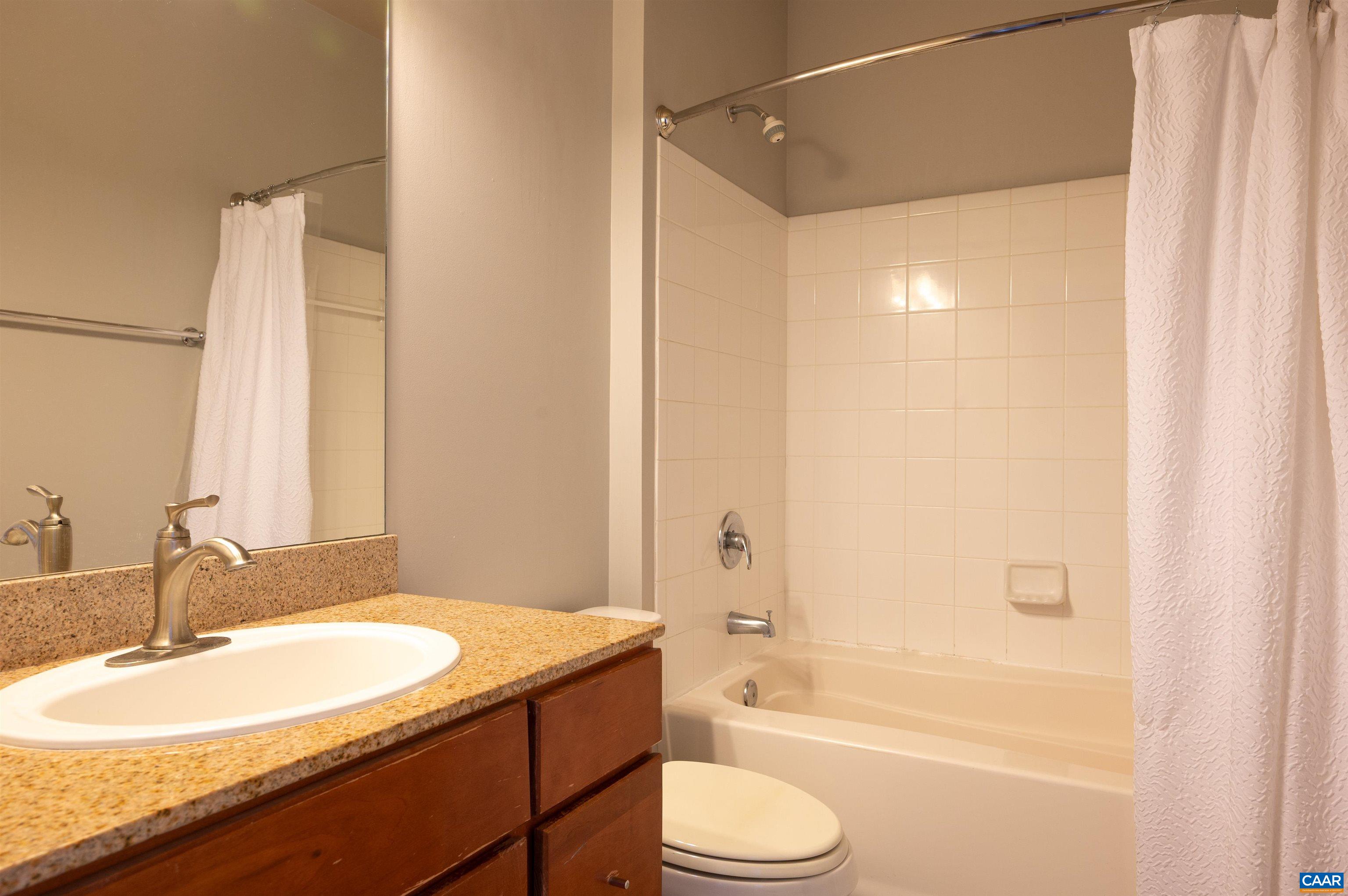 735 Walker Square, Unit 2A Charlottesville, VA 22903 - Photo 9 of 30 a bathroom with a granite countertop sink toilet and shower