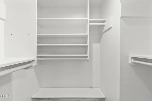 a view of walk in closet with empty racks