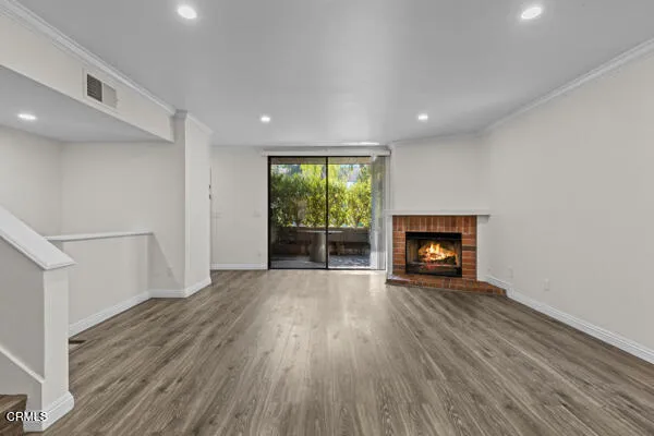 an empty room with wooden floor and fireplace
