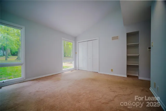 an empty room with windows and closet