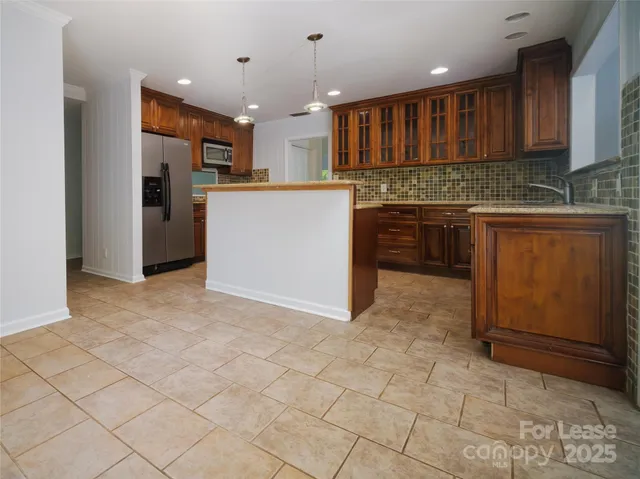 a kitchen with kitchen island granite countertop a stove a sink and a refrigerator