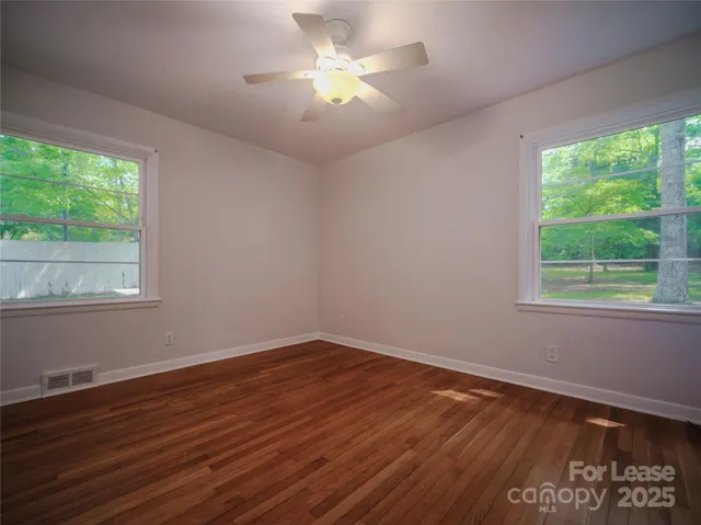 a view of a room with wooden floor and a window