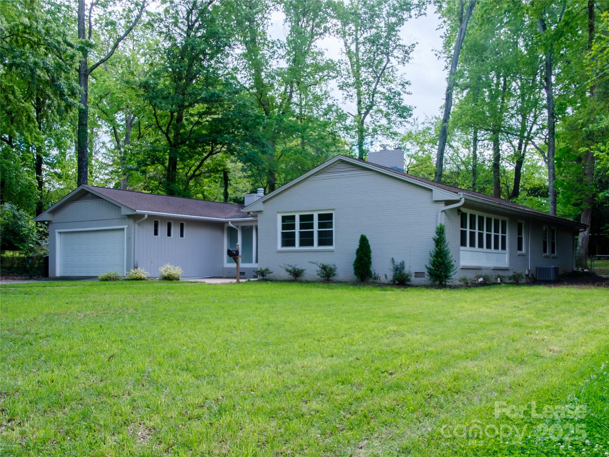 1123 Lynbrook Drive Charlotte, NC 28211 - Photo 45 of 47 a house that is sitting in the grass with large trees and wooden fence