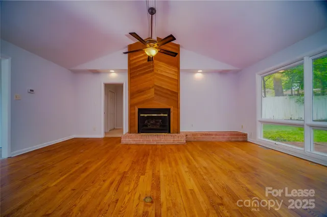 a view of an empty room with a fireplace and a window