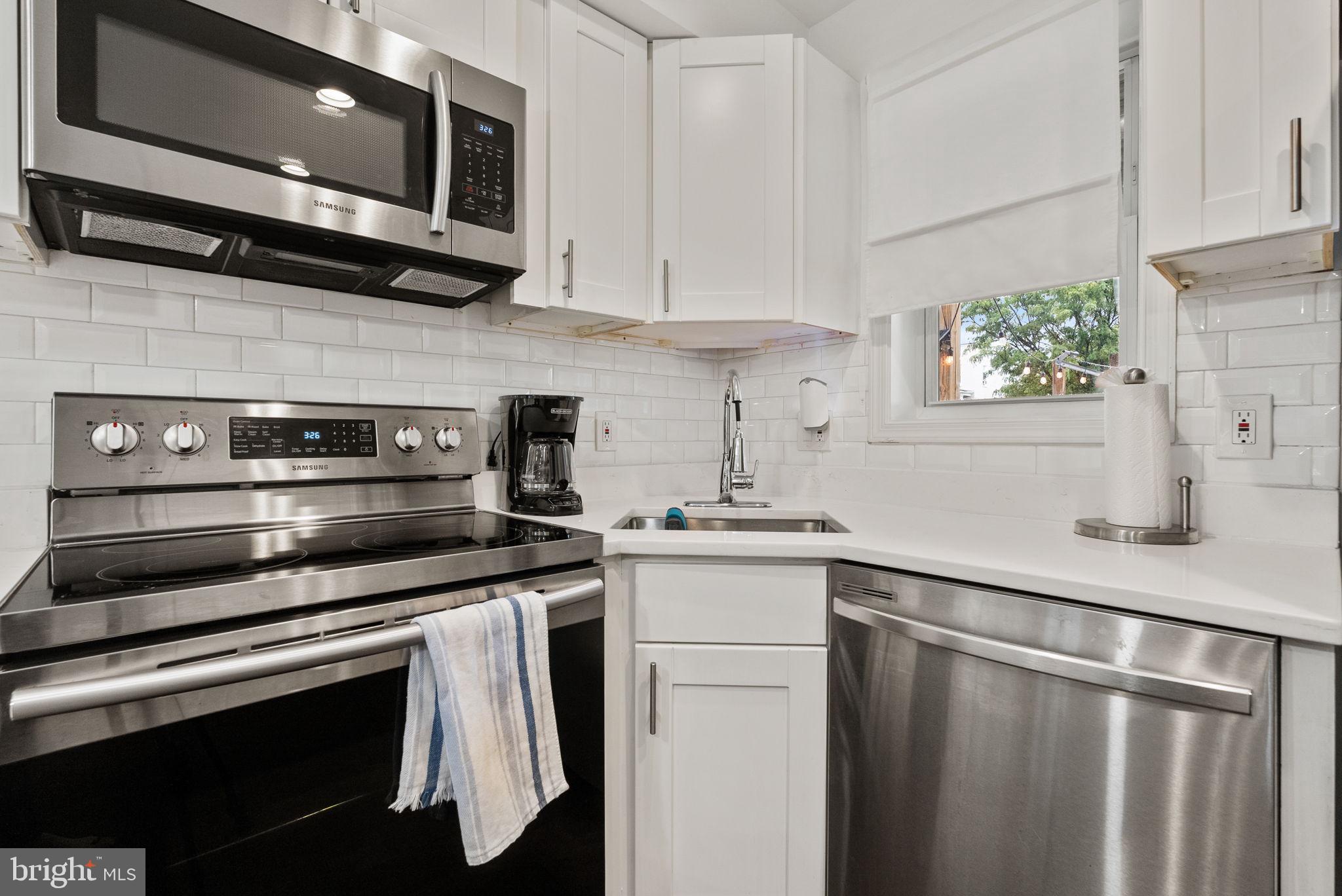2000 East A Street Northeast Washington, DC 20002 - Photo 12 of 26 a kitchen with stainless steel appliances a stove a sink and a microwave