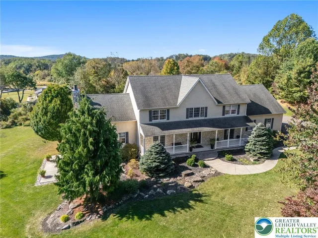 a aerial view of a house with a garden and lake view