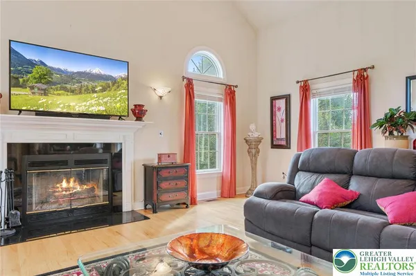 a living room with furniture a flat screen tv and a fireplace