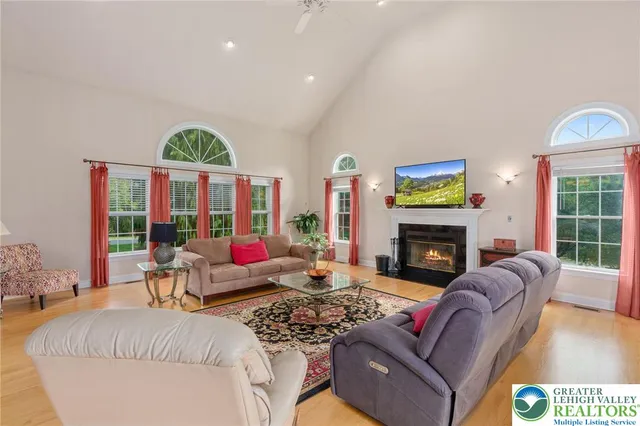 a living room with furniture fireplace and a large window