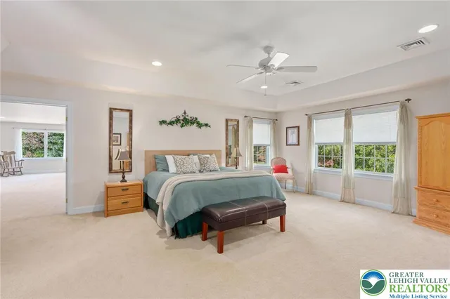 a spacious bedroom with a bed a couch and a window