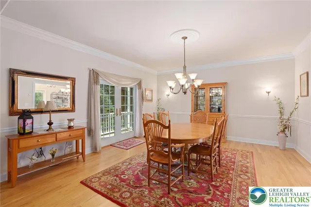 a dining room with furniture a chandelier and wooden floor