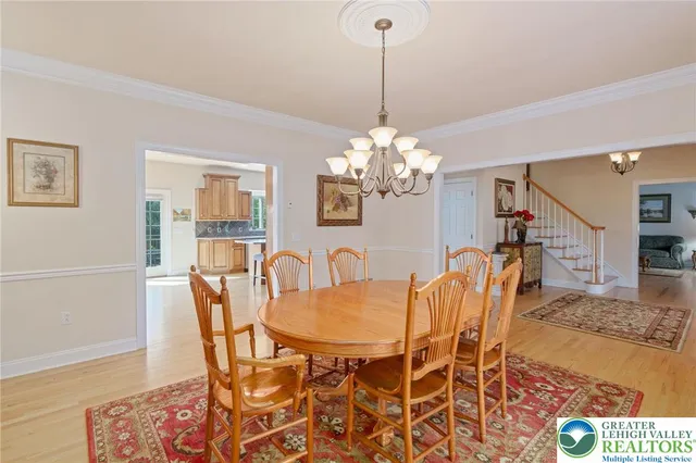 a dining room with furniture a chandelier and wooden floor