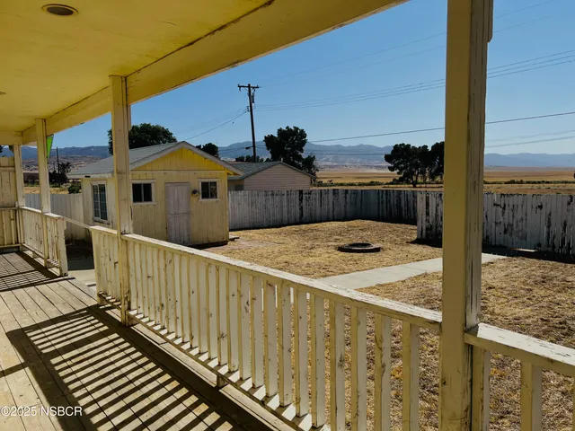 a view of a balcony with wooden floor and fence