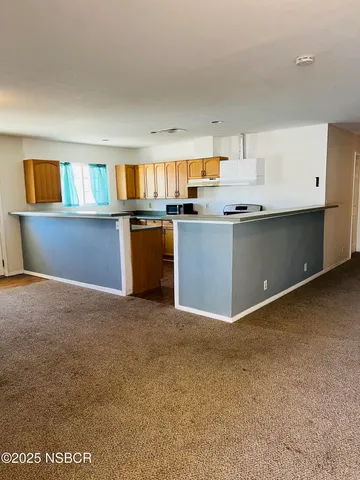 a kitchen with kitchen island a stove a sink and a refrigerator