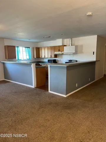 a kitchen with kitchen island granite countertop a sink cabinets and window