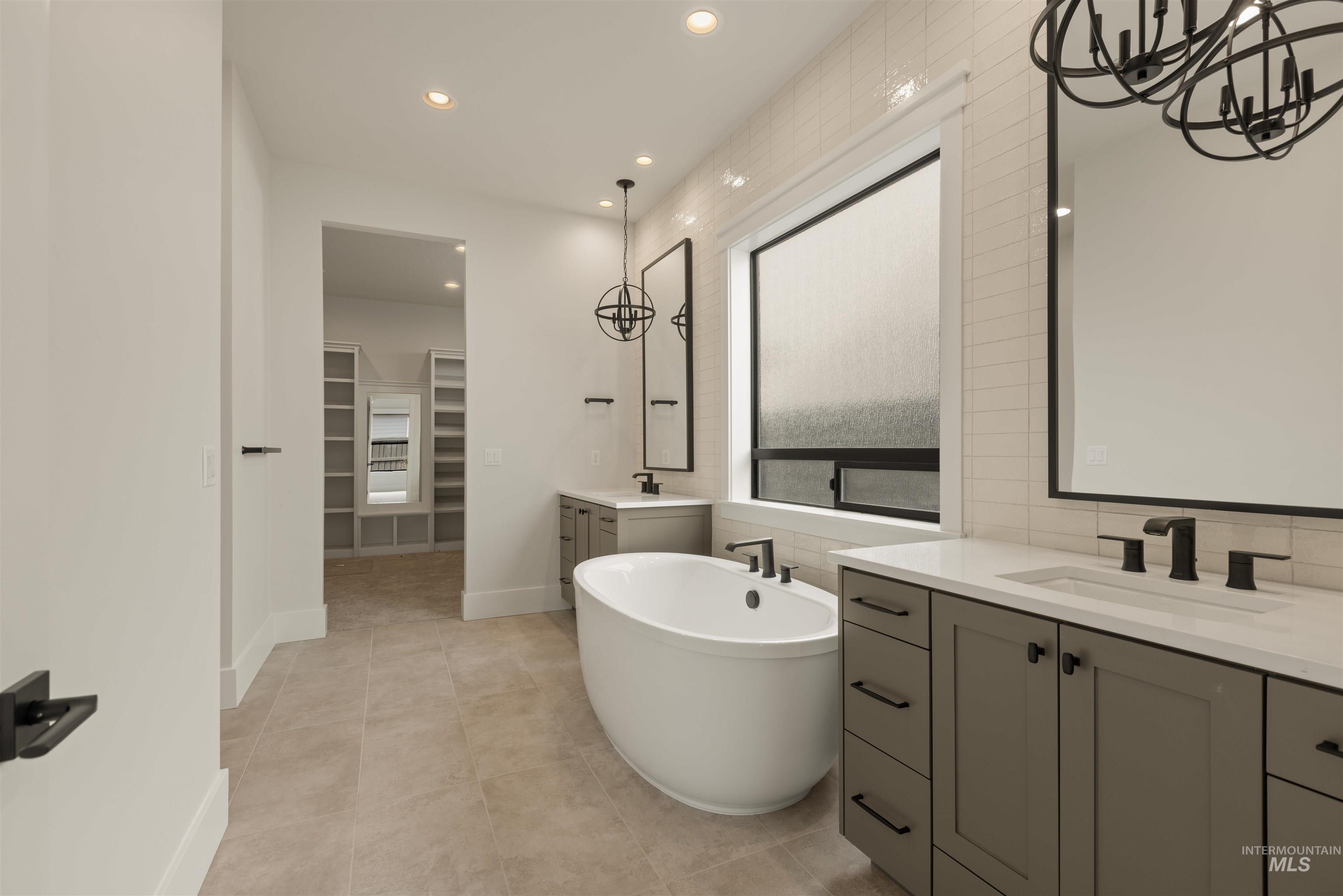 2595 East Tenzing Drive Meridian, ID 83642 - Photo 16 of 32 Full bath with a chandelier, two vanities, recessed lighting, a freestanding bath, and a spacious closet