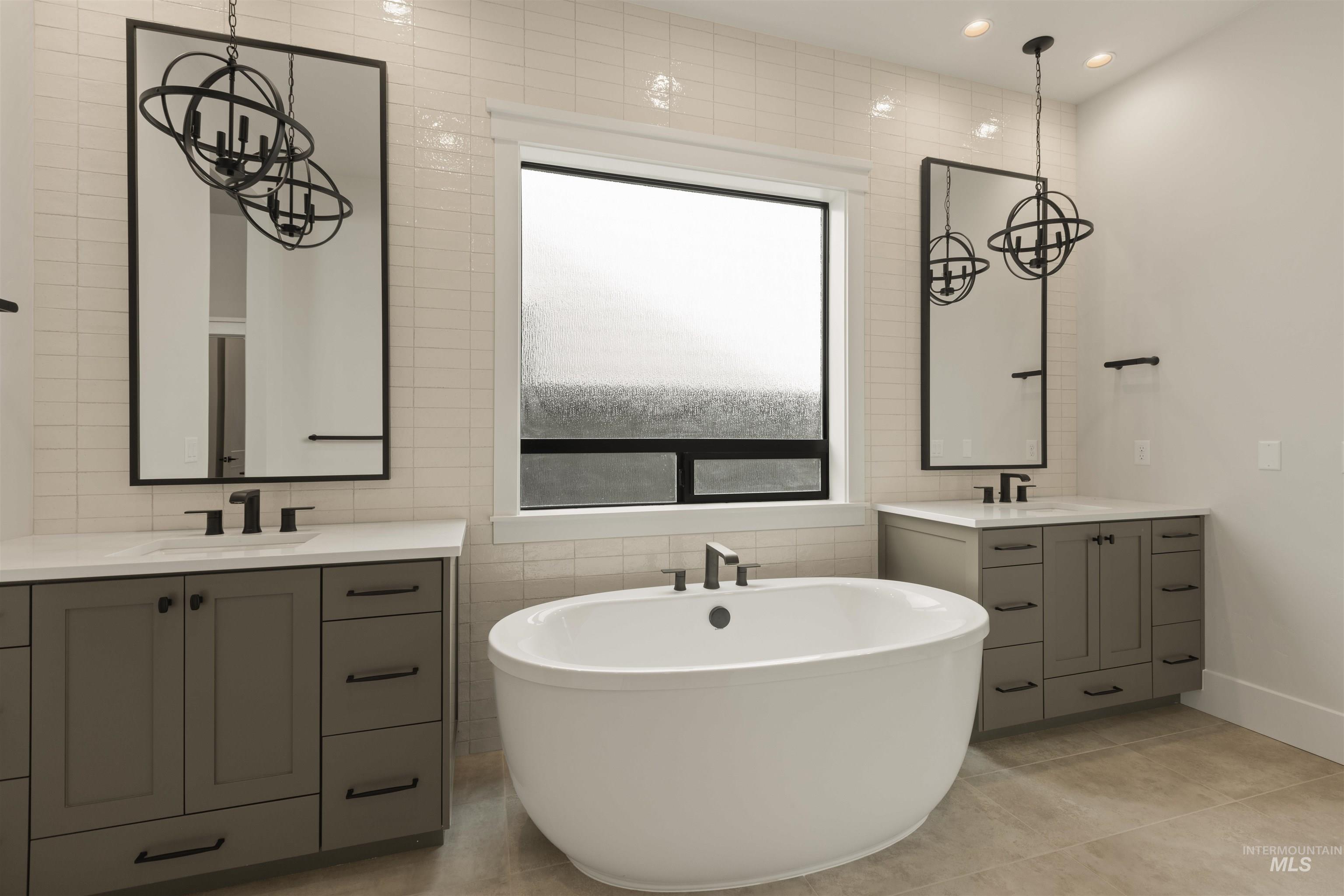 2595 East Tenzing Drive Meridian, ID 83642 - Photo 17 of 32 Full bathroom with tile walls, a soaking tub, two vanities, recessed lighting, and light tile patterned floors