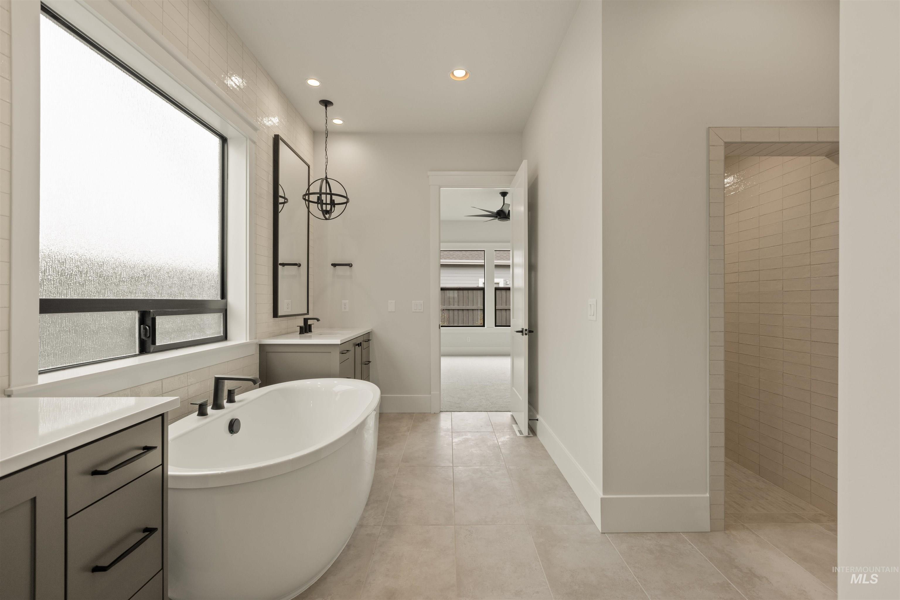 2595 East Tenzing Drive Meridian, ID 83642 - Photo 18 of 32 Full bath with vanity, a soaking tub, recessed lighting, ceiling fan, and light tile patterned flooring