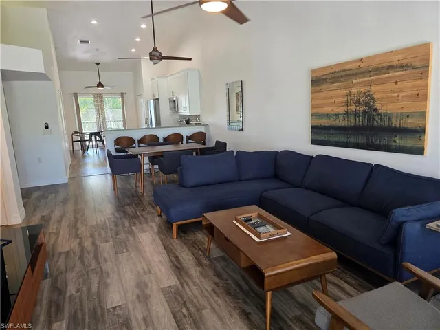 a living room with furniture a wooden floor and a chandelier