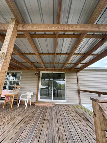 a swimming pool with lawn chairs and wooden floor