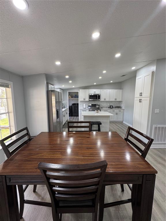 18806 Monroe Avenue Orlando, FL 32820 - Photo 25 of 44 a dining room with kitchen island a table and chairs