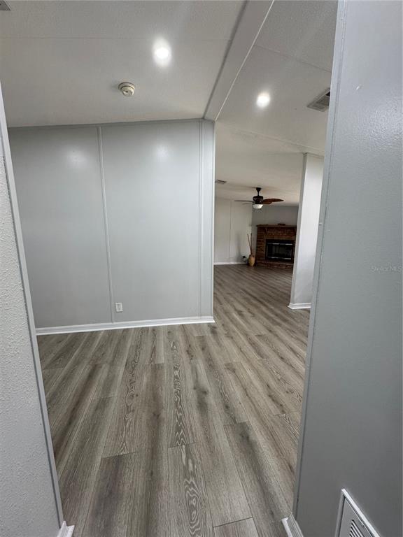 18806 Monroe Avenue Orlando, FL 32820 - Photo 30 of 44 an empty room with wooden floor cabinet and a kitchen view