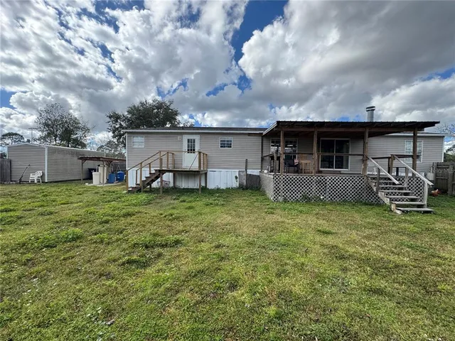 a view of a house with backyard and a garden