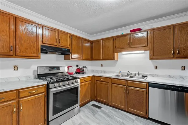 a kitchen with stainless steel appliances granite countertop a sink stove and cabinets