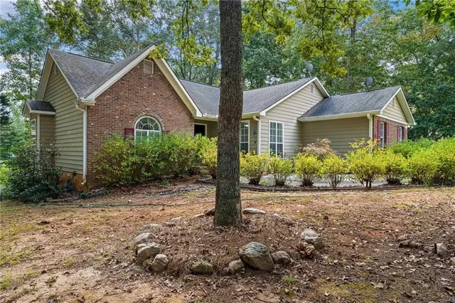 a front view of house with yard and trees around