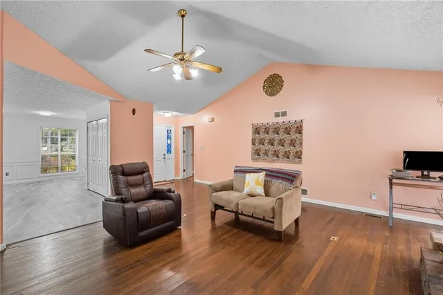 a living room with furniture and a wooden floor