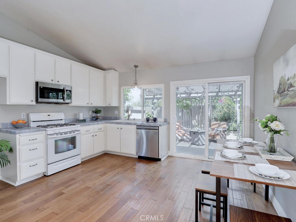 22661 Claude Circle Lake Forest, CA 92630 - Photo 7 of 50 a kitchen with white cabinets and wooden floor