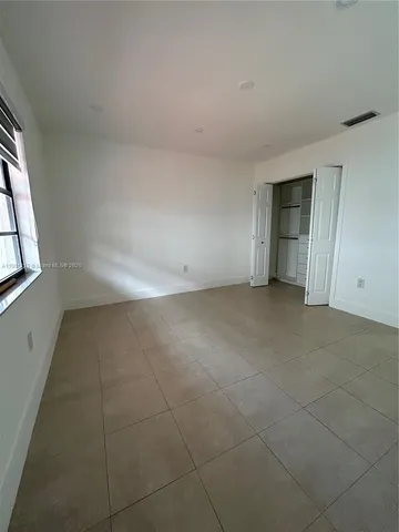 an empty room with a empty space and windows