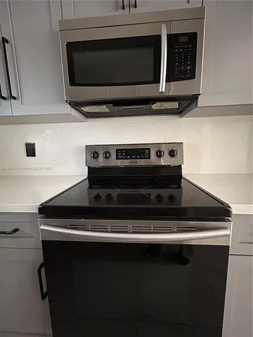 a kitchen with stainless steel appliances and refrigerator