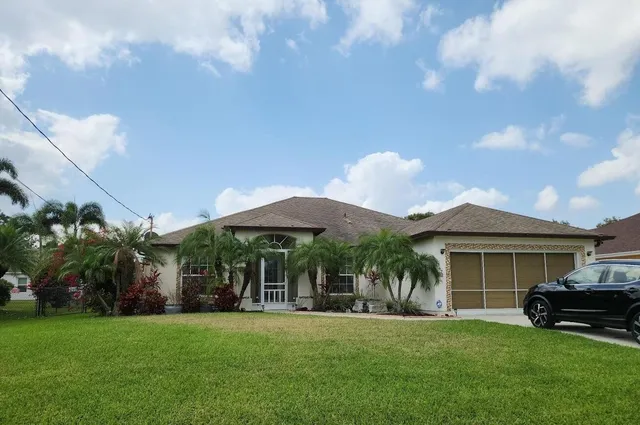 a view of a house with a yard and sitting area