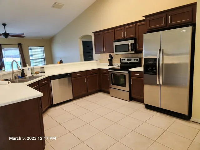 a kitchen with stainless steel appliances a sink cabinets and a refrigerator