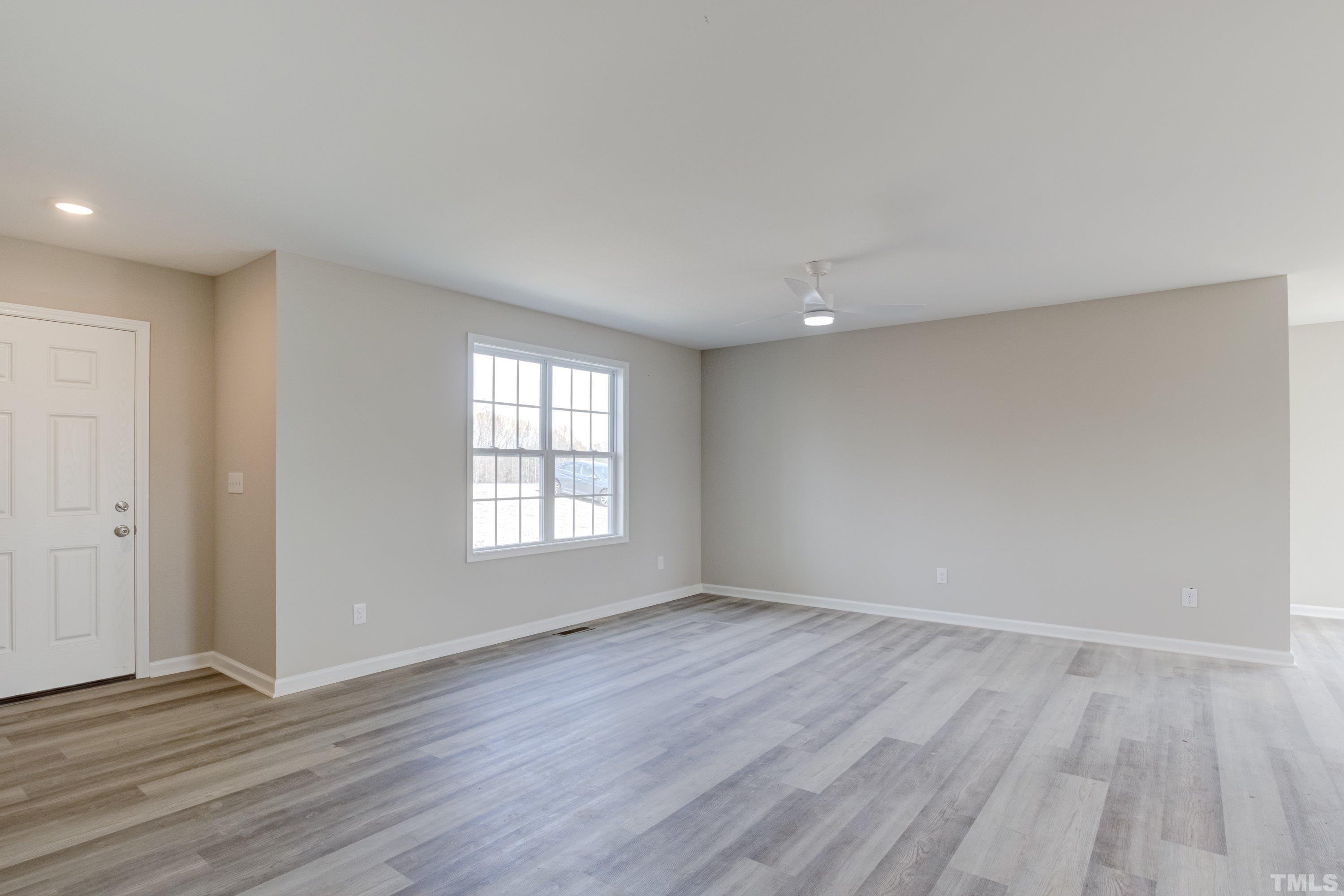 2541 Pilot-Riley Road Zebulon, NC 27597 - Photo 6 of 34 a view of an empty room with wooden floor and window