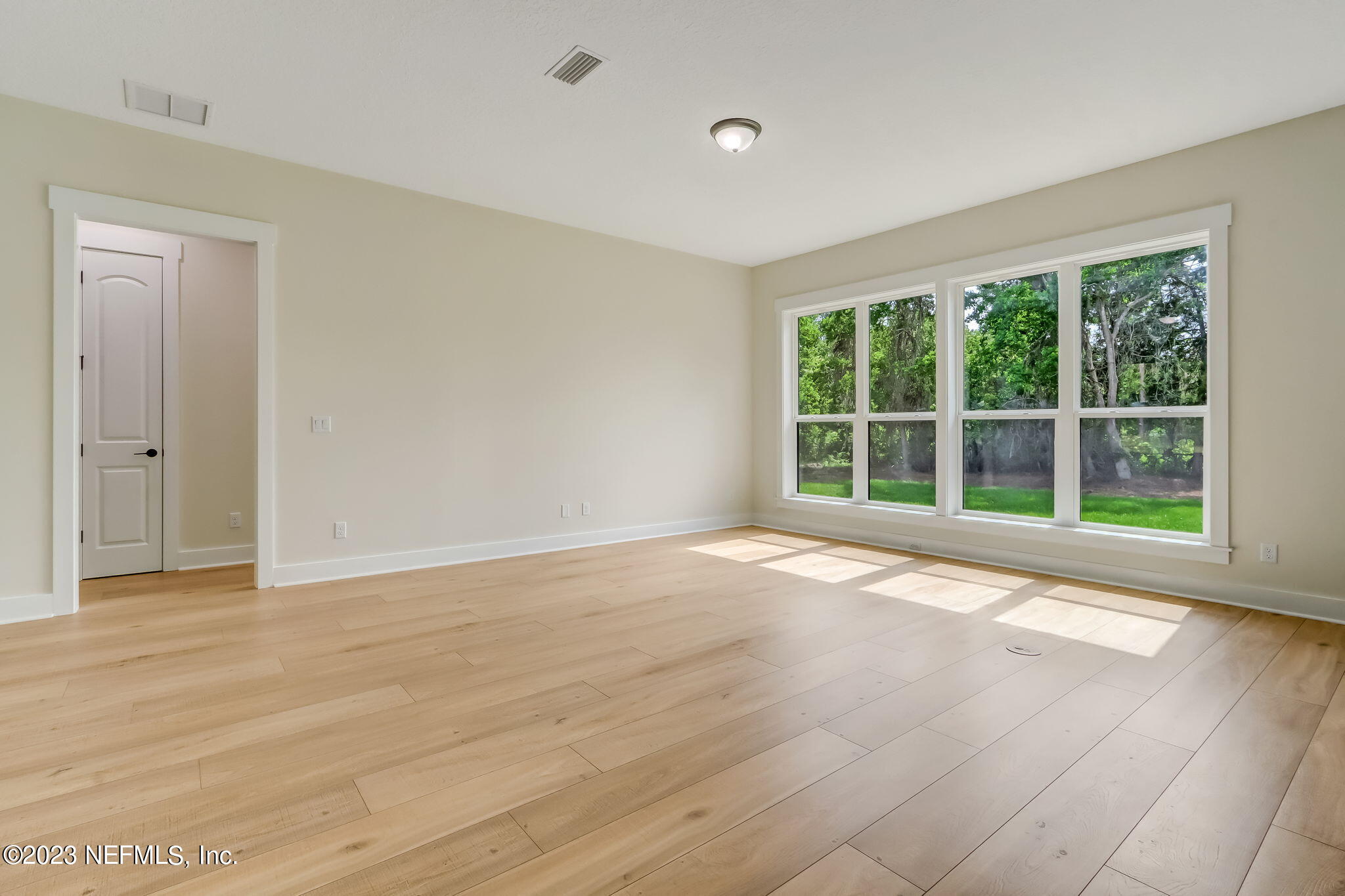 86277 Peeples Road Yulee, FL 32097 - Photo 11 of 36 a view of an empty room with wooden floor and windows