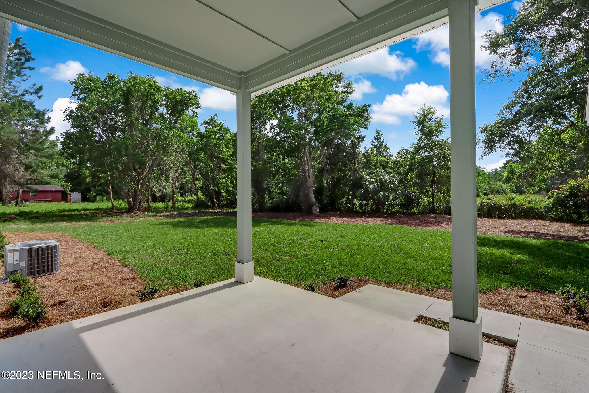 86277 Peeples Road Yulee, FL 32097 - Photo 4 of 36 a view of a porch with a big yard potted plants and large tree