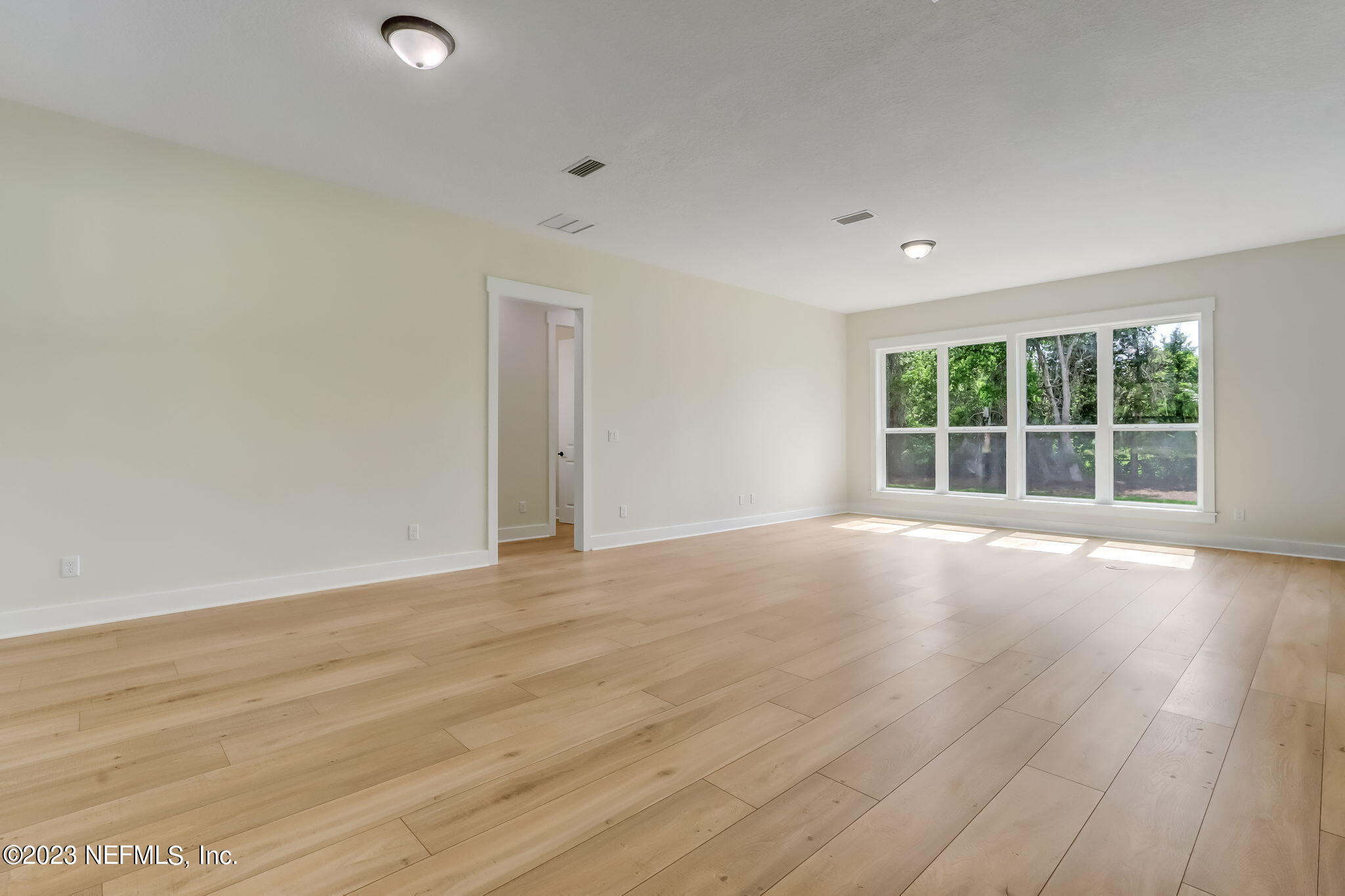 86277 Peeples Road Yulee, FL 32097 - Photo 7 of 36 an empty room with wooden floor and windows