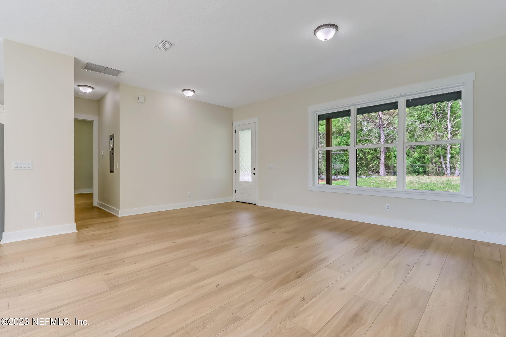86277 Peeples Road Yulee, FL 32097 - Photo 9 of 36 a view of an empty room with wooden floor and a window
