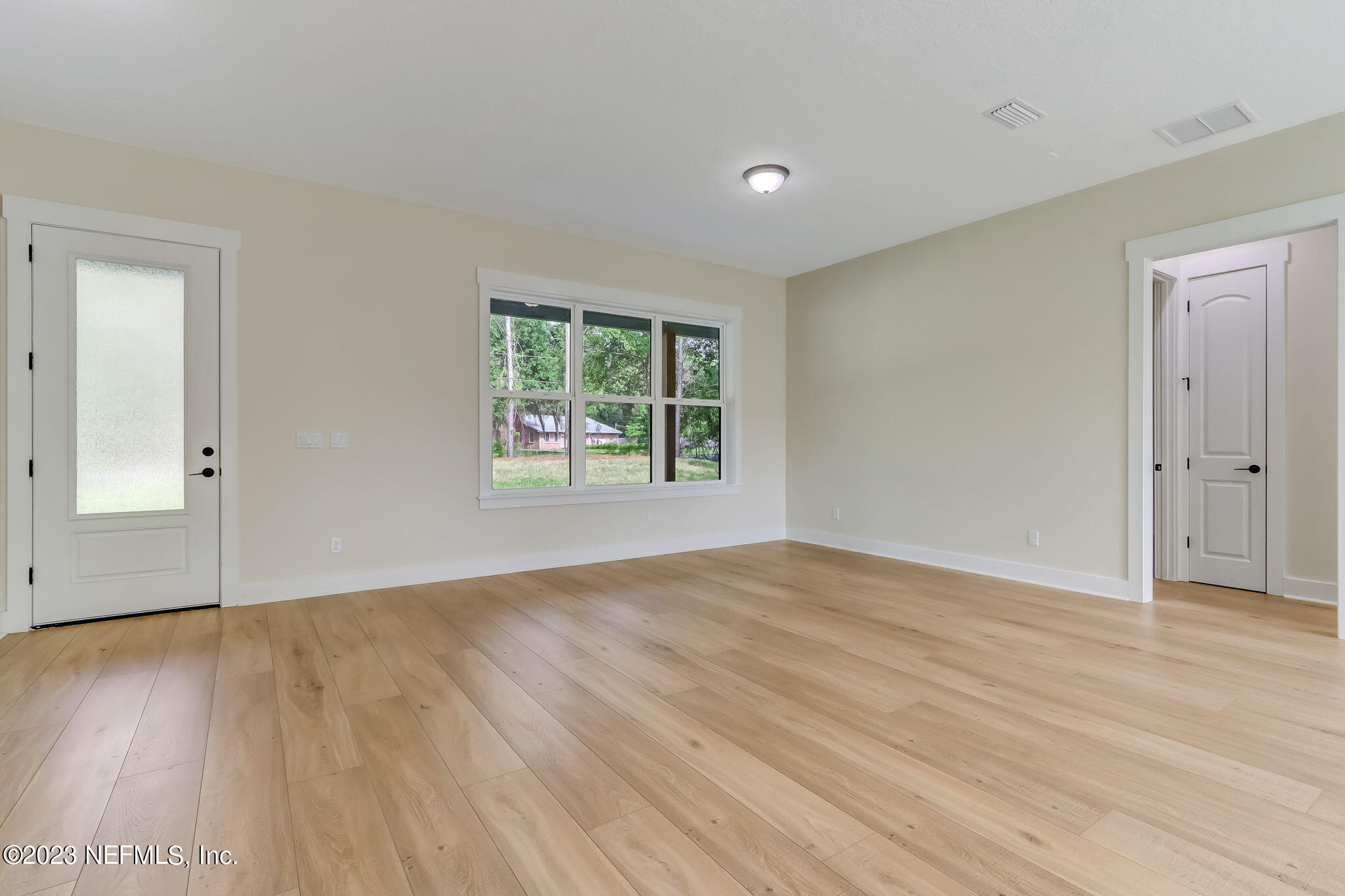 86277 Peeples Road Yulee, FL 32097 - Photo 10 of 36 an empty room with wooden floor and windows