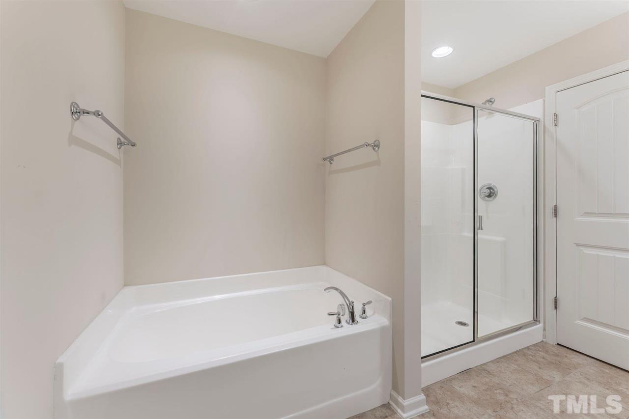 2431 Swans Rest Way Raleigh, NC 27606 - Photo 17 of 25 a bathroom with a bathtub and a shower
