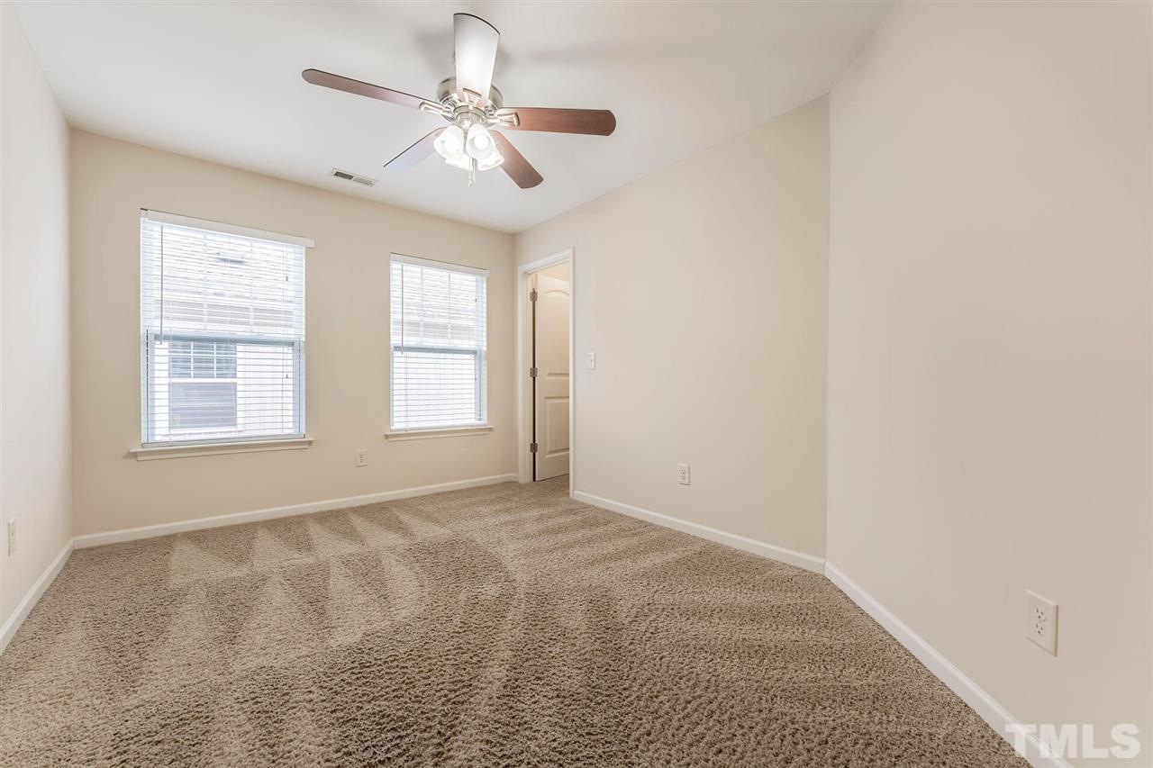 2431 Swans Rest Way Raleigh, NC 27606 - Photo 18 of 25 an empty room with windows and fan